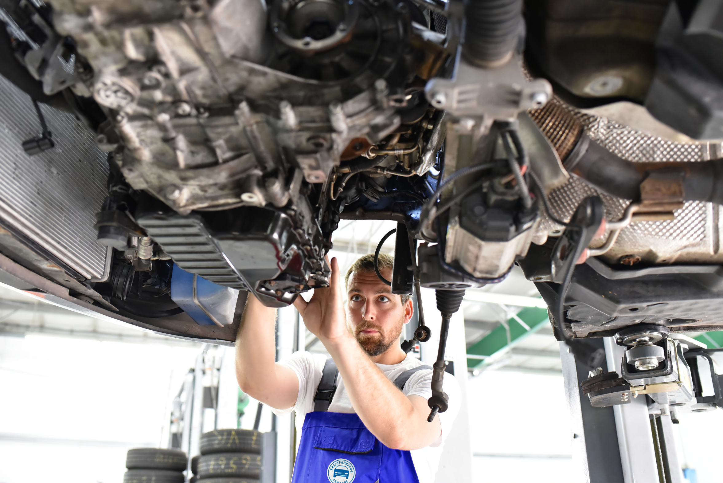 Automechaniker repariert defektes Fahrzeug auf der Hebebhne in e